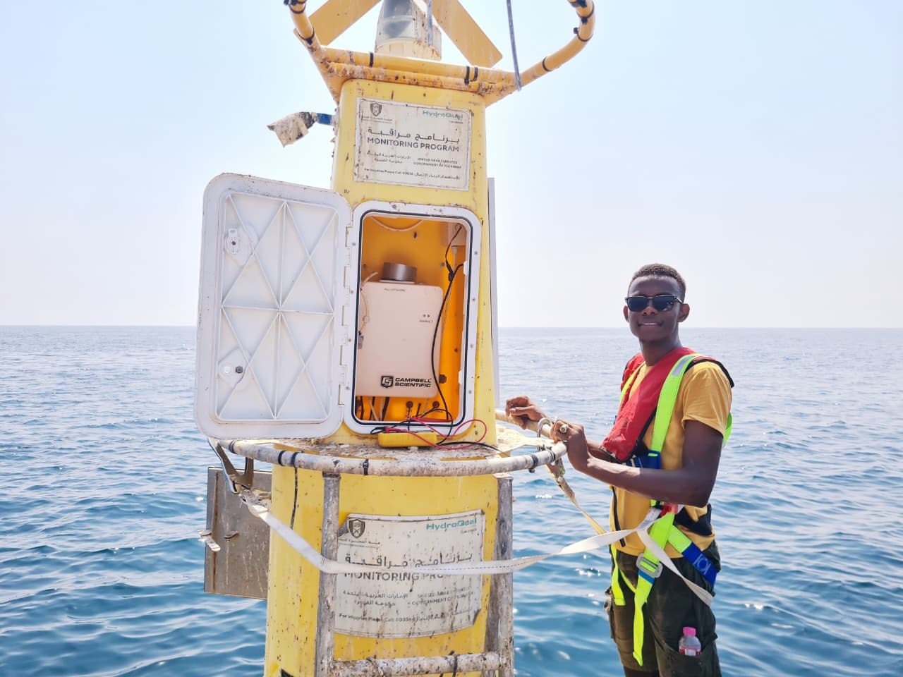 Husam beside an open offshore water-quality monitoring buoy in Fujairah