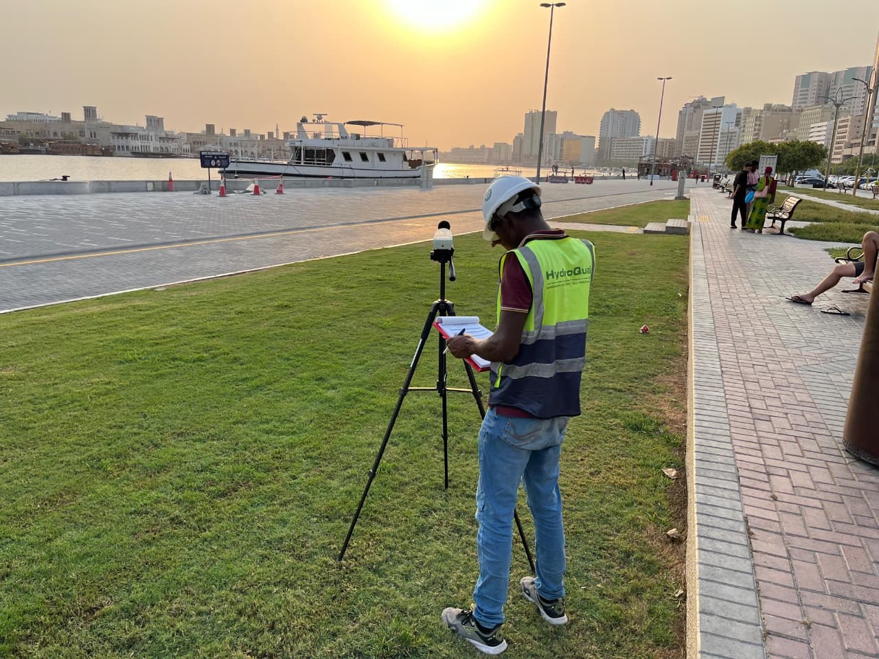 Husam reviewing field measurements beside an environmental monitoring instrument