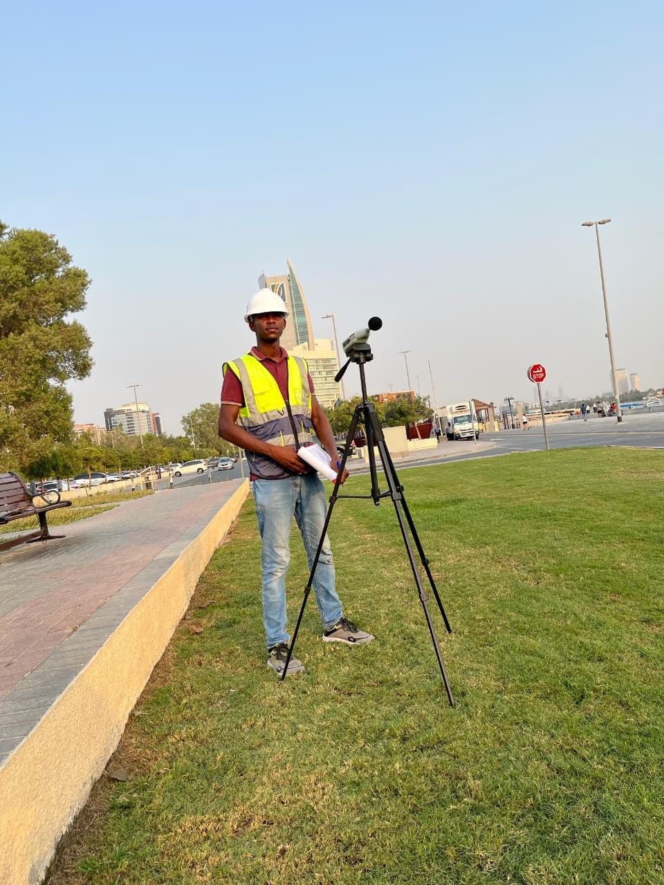 Husam beside a field monitoring instrument mounted on a tripod
